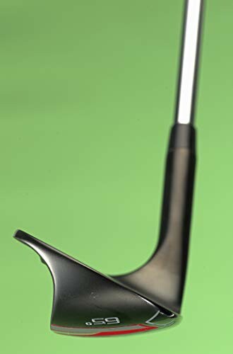 Close-up of a golf club wedge on a green background